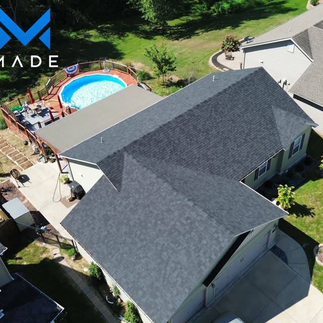 Aerial view of a completed residential roof beside a pool